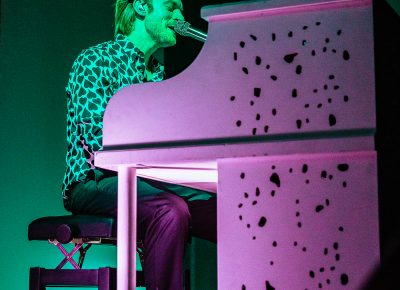 FINNEAS takes to the white piano in center stage.