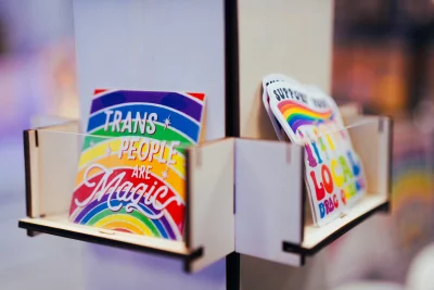Two wooden shelves holding pride stickers. 