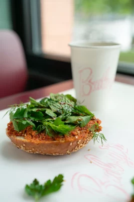 A Muhammara bagel sandwich and a coffee at Baby's Bagels.
