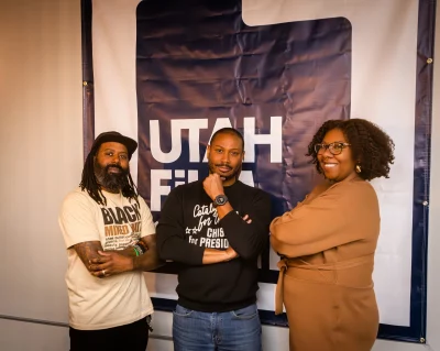 (From L-R) Risshan Leaks, Russell Roots, and Asha Washington stand in front of Utah Film Center poster.