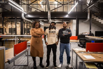 Aja Washington, Risshan Leaks and Russell Roots stand side by side in their office space. 