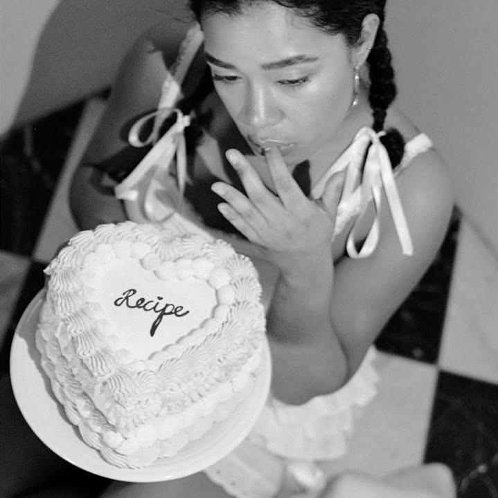 Album cover with a woman eating a cake on the cover.