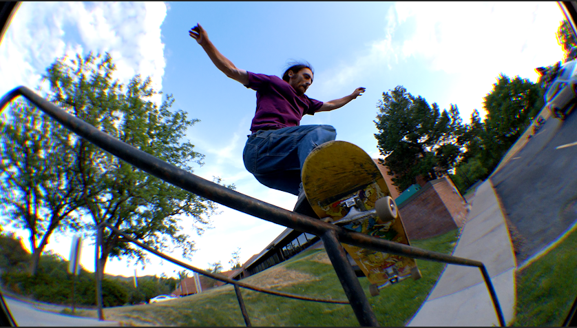 A skater grinds on a rail.
