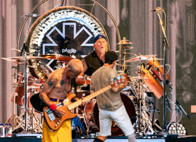 Red Hot Chili Peppers members Flea and Anthony Kiedis play on stage with drummer Chad Smith vocalizing toward Kiedis while he roams the stage at the Utah First Credit Union Amphitheatre. Photo: @lmsorenson