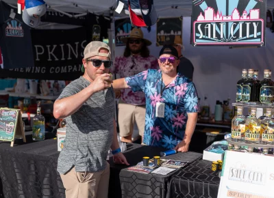 (Left to right, Matt and Aaron) Matt put on his finest SLC Vodka glasses and threw back a drink from Aaron manning the booth. Photo: Chay Mosqueda.