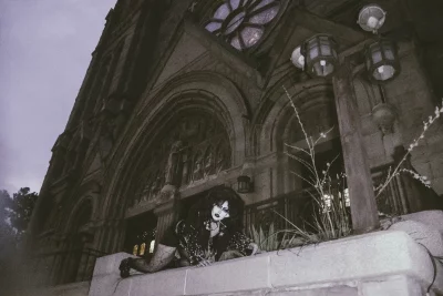 Cherry Poppins crawls in front of a cathedral. 