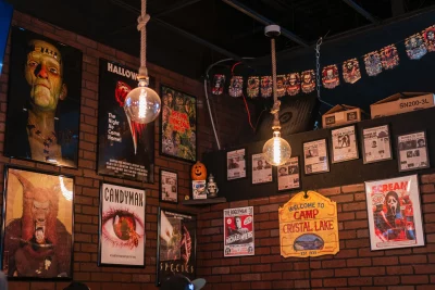 Burgertory's interior decorated with a variety of classic horror movie posters and 2 large lights hanging down from the ceiling