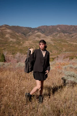 Chloe Akira stands in a field with a bag in her hand