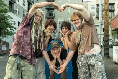 Two of the members of Lovelace hold their arms out to create a heart while the other three stand in the middle of it. 