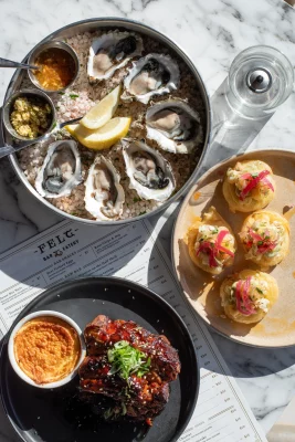 An order of Oysters on the Half Shell, Prawn Aguachile Tartine and Korean BBQ Backribs