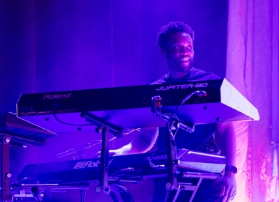 Griff's keyboard player is all smiles on stage. Photo: Derek Brad.