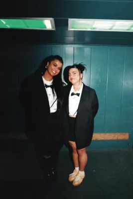 Drew and Noelle Afualo stand in front of a blue wall.