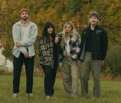 Band The National Parks stands in a fall-esque field. They each look at the camera.