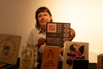 Rachael Hall holding up the book, Riso Geist.