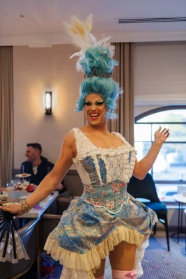 Erin Judgement poses in a blue, Marie Antoinette-esque wig and matching dress. 