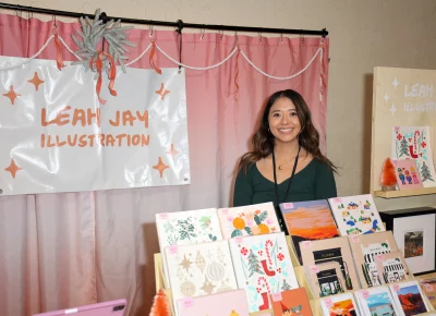 Leah Jay illustration poses with her work. Photo: John Barkiple.